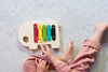 A child playing with the Petit Collage Wooden Elephant Xylophone.
