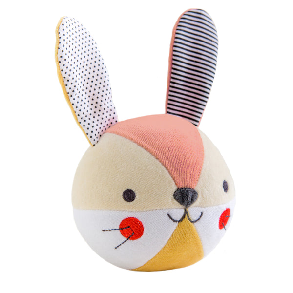 The Petit Collage Organic Bunny Soft Chime Ball is a round plush toy shaped like a bunnys head, featuring large patterned ears, red cheeks, and a stitched face on a white background.