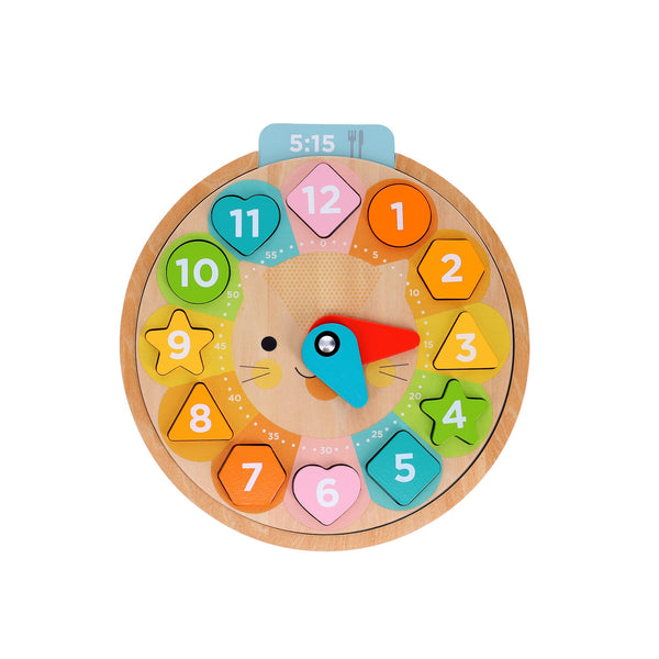 The Petit Collage Multi-Language + Counting + Colors Wooden Learning Clock features colorful numbered hour shapes, blue and red movable hands, and a cat face at the center, set to 5:15.