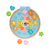 The Petit Collage Multi-Language + Counting + Colors Wooden Learning Clock is a colorful toy with removable numbered shapes and a vibrant clock face, designed to teach time, colors, and counting.
