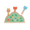 The Petit Friends Wooden Pop-Up Toy by Petit Collage features three animal figures—a cat, fox, and bear—on springs in a green leaf-, flower-, and mushroom-decorated base.