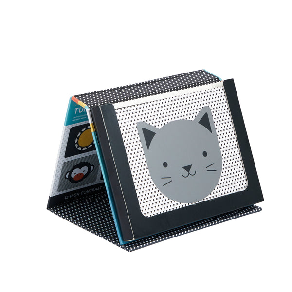 The Tummy Time Peekaboo by Petit Collage is a black and white tent-shaped baby book with a simple gray cat on the cover and other high-contrast images inside.