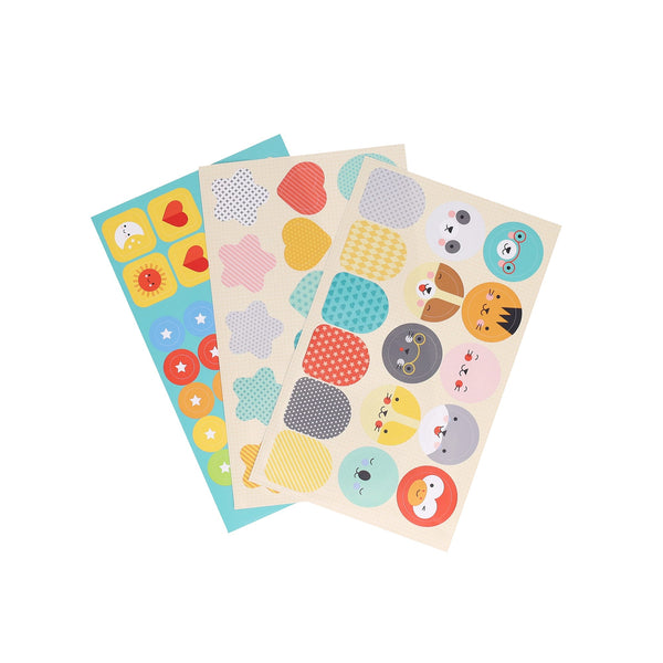 Three sheets from the Petit Collage Petit Friends Puppet Theatre Set with colorful stickers of various shapes, patterns, and cartoon faces arranged in rows.