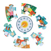 The Petit Collage Telling the Time 25-Piece Floor Puzzle features a round clock with a sun center, surrounded by six colorful puzzle pieces, each displaying illustrated animals and numbers.