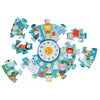 The Petit Collage Telling the Time 25-Piece Floor Puzzle features a vibrant animal design surrounding a central clock face with movable hour and minute hands.