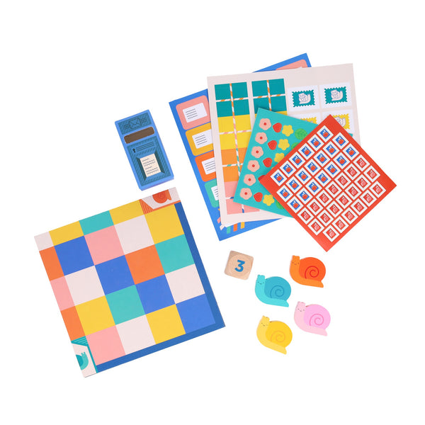 Snail Express by Petit Collage features a multicolored grid board, snail-shaped cardboard cutouts, number tokens, illustrated stamp sheets, and a blue card box—colorfully arranged on a white background.