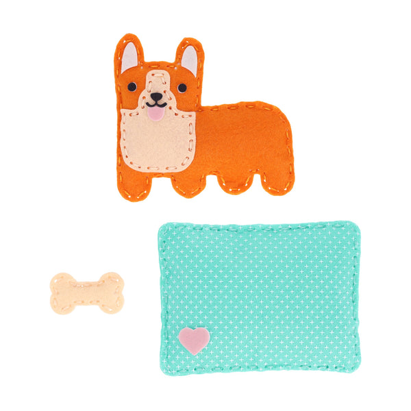 The Petit Collage Mini Craft Kit: Pocket Pet Corgi includes a felt corgi toy in orange and cream, a small beige bone, and a turquoise dotted mat with a pink heart.