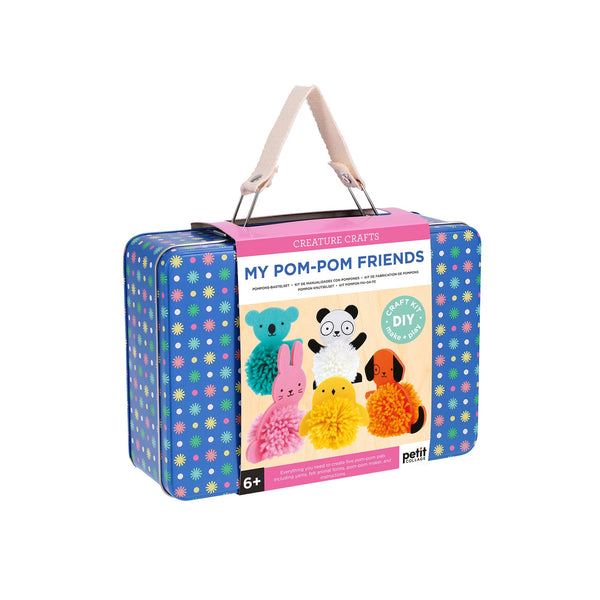The Petit Collage Creature Crafts: My Pom-Pom Friends kit is a blue and pink suitcase with animal pom-pom images and a beige handle, designed for kids ages 6+.