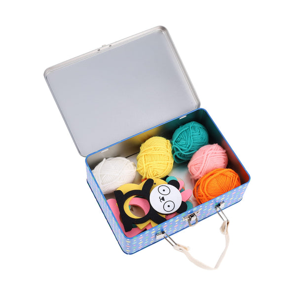 The Petit Collage Creature Crafts: My Pom-Pom Friends kit features a blue metal case with a handle holding six colorful yarn balls and a panda bear craft mask.