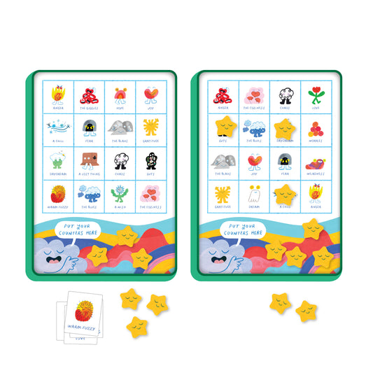 The Finding Things Bingo: A Magnetic Travel Game by Petit Collage includes two bingo boards with illustrated emotion faces and names, yellow star tokens, and an emotion card featuring Warm Fuzzy, a red and yellow fluffy character.