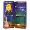 The Music Maker Shine Bright Magnetic Play Set by Petit Collage includes a girl with headphones, guitar, keyboard, microphone, tambourine, and a decorative background with lights, bird, and music notes—all in a purple case.