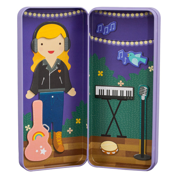 The Music Maker Shine Bright Magnetic Play Set by Petit Collage includes a girl with headphones, guitar, keyboard, microphone, tambourine, and a decorative background with lights, bird, and music notes—all in a purple case.