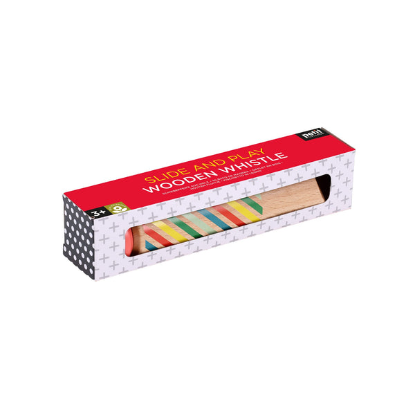 A boxed Petit Collage Slide and Play Wooden Whistle toy is shown, featuring a colorful whistle visible through a window in the packaging.
