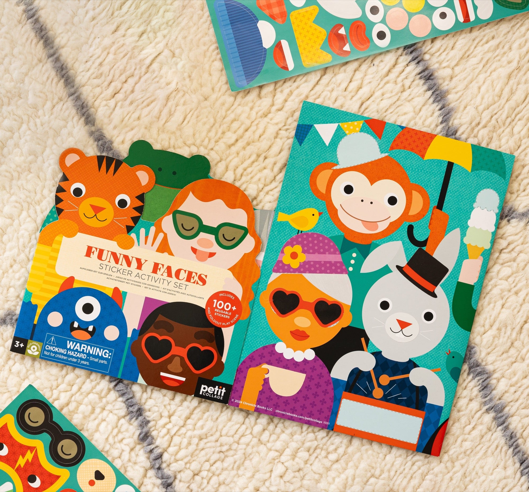 The Petit Collage Sticker Activity Set: Funny Faces features colorful, mix-and-match cartoon animal and people stickers with facial features on a patterned carpet.