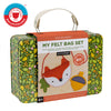 The Petit Collage DIY Woodland Fox Felt Bag is a green floral-patterned suitcase for ages 6+, featuring a fox and acorn felt craft kit, white handle, and Good Play Guide Recommended badge.