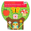 The Petit Collage Little Tree On the Go Wood Puzzle + Play is a tree-shaped wooden puzzle featuring pieces like an apple, butterfly, mushroom, and owl, designed for ages 18 months and up.