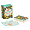 A box of Petit Collage Dinosaurs Trivia Quiz Cards sits beside a stack of illustrated cards, with three cards spread out to display dinosaur-themed questions and answers.