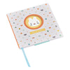 The Petit Collage Bunny Baby Journal is a square book with a white cover, featuring a cartoon bunny face, colorful icons, and HELLO BABY! in a yellow banner below the illustration.