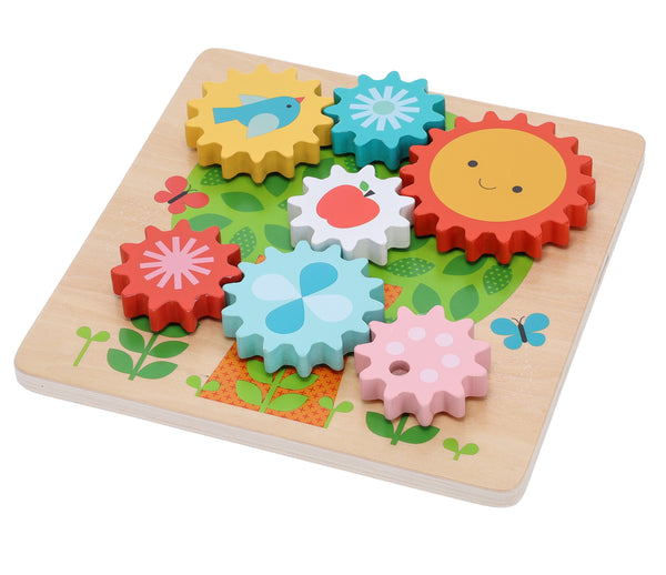 The Busy Tree Wooden Twist Puzzle by Petit Collage is a wooden board with colorful interlocking gears, each featuring patterns like a sun, fish, flower, and fruit on a floral background.