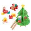 The Petit Collage Christmas Treehouse Wooden Play Set includes a green tree, yellow star, ladder, animal figures, gift boxes, campfire, red car, and a mushroom-shaped table with chairs.