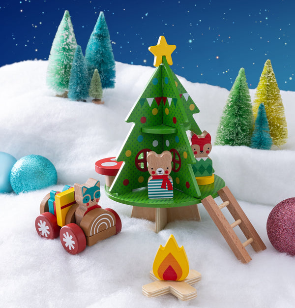 Create a festive scene with the Petit Collage Christmas Treehouse Wooden Play Set, featuring wooden animals, a decorated treehouse, ladder, campfire, toy car, snowy grounds, ornaments, and bottlebrush trees under a starry night.