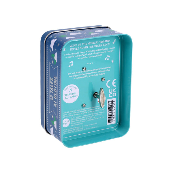 The Petit Collage "12 Tales at Bedtime" is a rectangular metal tin with a wind-up key that plays “Brahms Lullaby.” Labeled for bedtime stories, its interior and sides feature instructions and musical notes.
