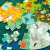 A partially completed Floor Puzzle: My Planet Earth by Petit Collage is shown on a green carpet, featuring illustrated land and sea animals encircling an image of the Earth.