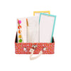 The Petit Collage Mini Masterpieces My Painting Set is a small red case with white patterns that holds notepads, a paintbrush, a pencil, and colorful round stickers.