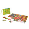 The Petit Collage Two-sided Woodland On-the-Go Puzzle features animal-themed pieces, some loose, and comes with a green zippered pouch decorated with a red mushroom pattern.