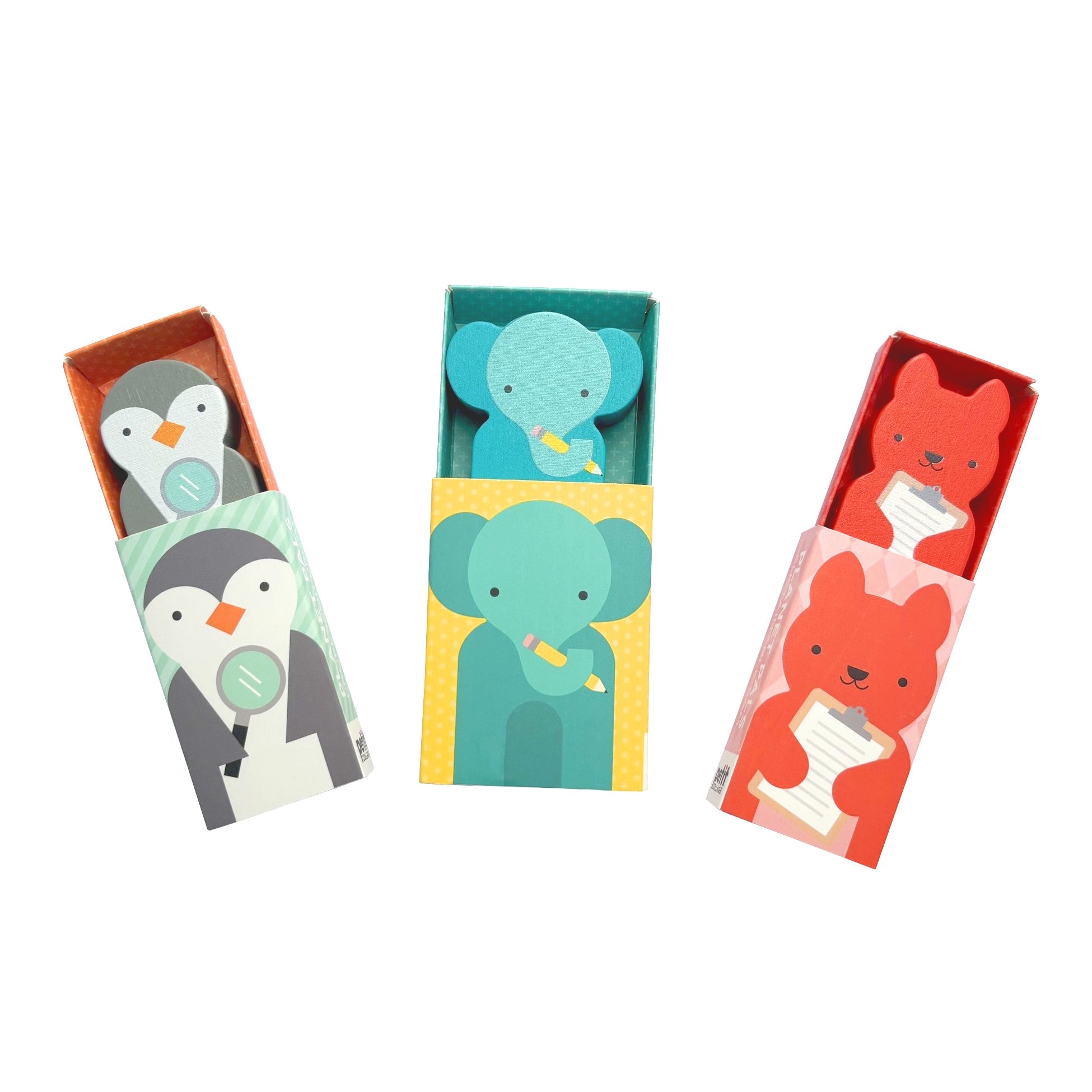 Three matchbox-style boxes from Petit Collage feature animal designs—such as the Wooden Planet Pal: Professor Peggy—and each contains a matching wooden animal figure holding a small white object.
