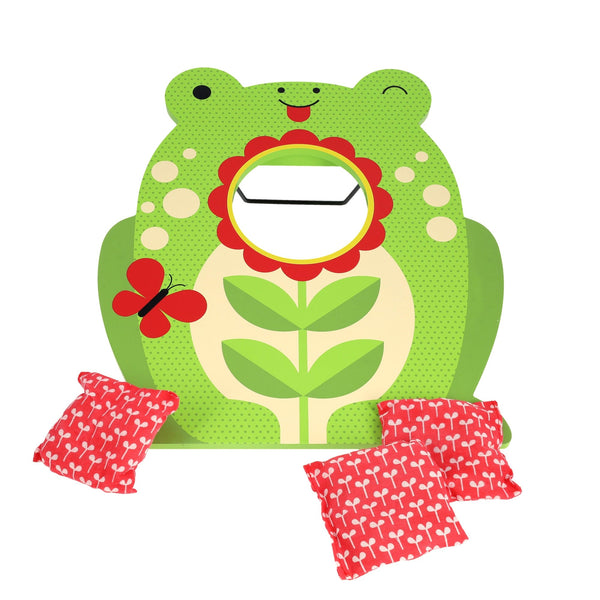 The Petit Collage Toadstool Toss Wooden Cornhole Game features a green frog board with a flower-shaped target hole, three red patterned bean bags, and a red butterfly accent.